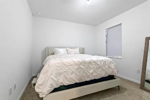 a bed sitting in a bedroom next to a window