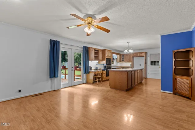 a living room with stainless steel appliances furniture and a kitchen view