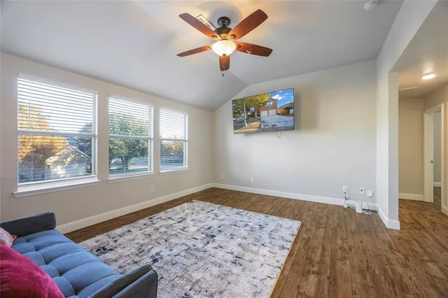 a view of a livingroom with wooden floor and a ceiling fan