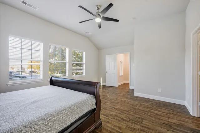 a spacious bedroom with a bed and a large window