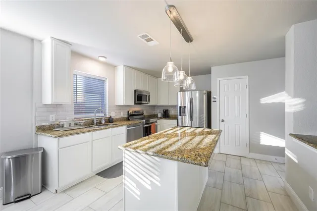a kitchen with stainless steel appliances a refrigerator sink and cabinets