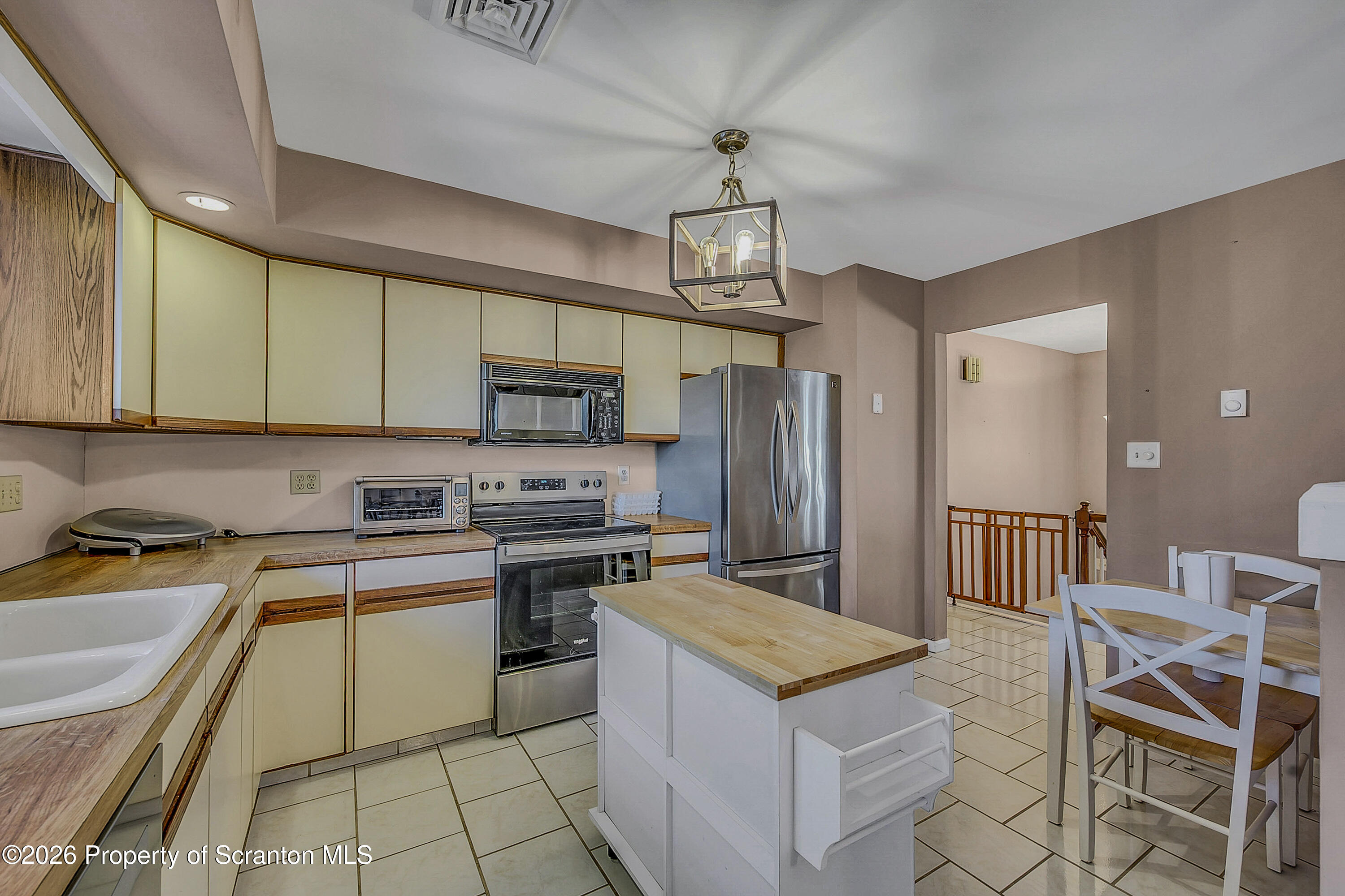 102 Glenstone Road Dickson City, PA 18519 - Photo 9 of 39 a kitchen with stainless steel appliances granite countertop a sink a stove a refrigerator cabinets and chairs