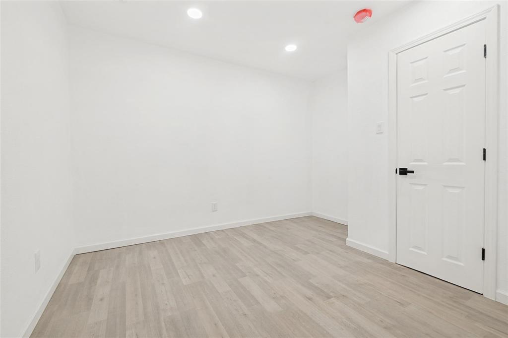 2908 Legend Road Arlington, TX 76014 - Photo 15 of 29 Minimalist room featuring light wood-finish flooring, recessed lighting, and a white paneled door with matte black hardware