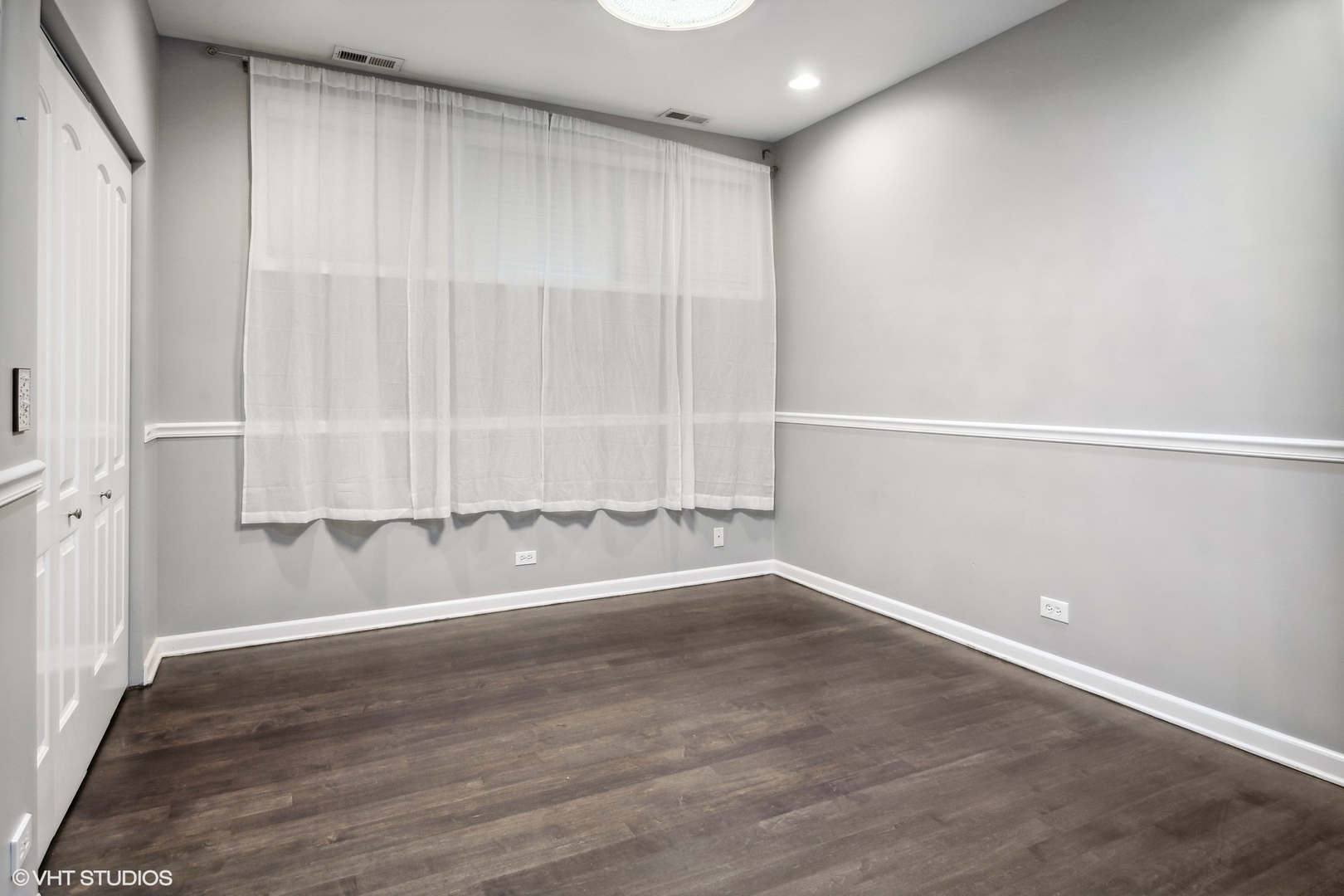 3404 North Seminary Avenue, Unit 1 Chicago, IL 60657 - Photo 12 of 15 an empty room with wooden floor and windows with curtains