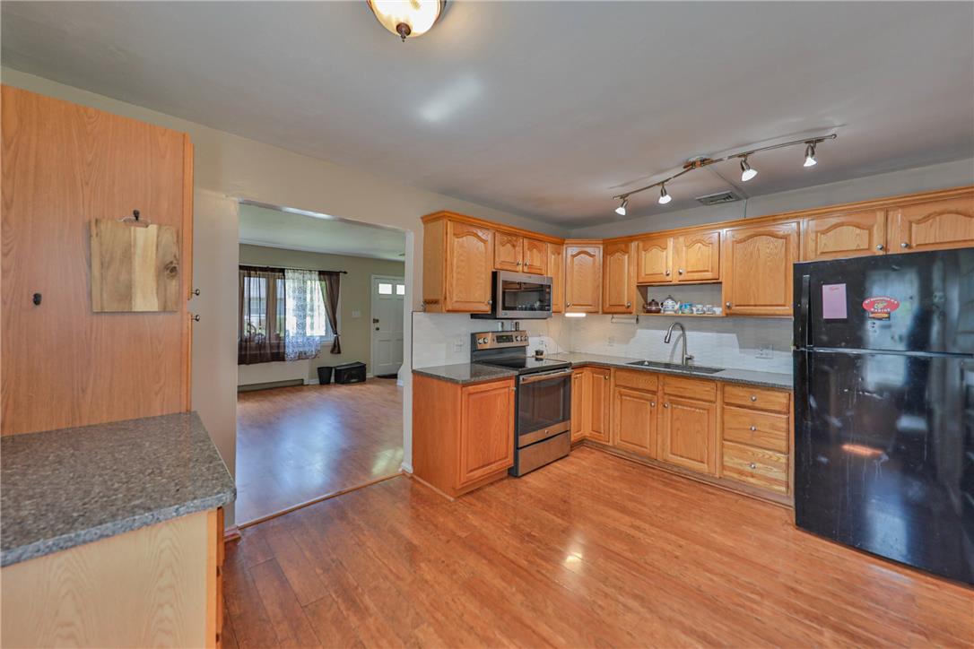 3050 Cornwall Road Bethlehem, PA 18017 - Photo 18 of 80 A well-lit kitchen with natural wood cabinetry connects to a spacious living area.