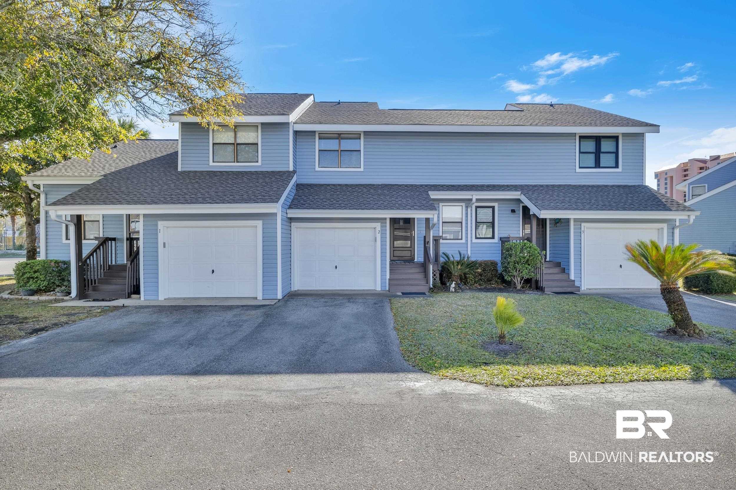 3256 Loop Road, Unit 2 Orange Beach, AL 36561 - Photo 3 of 25 Light blue siding exterior with multiple garage doors and individual entrance stairs