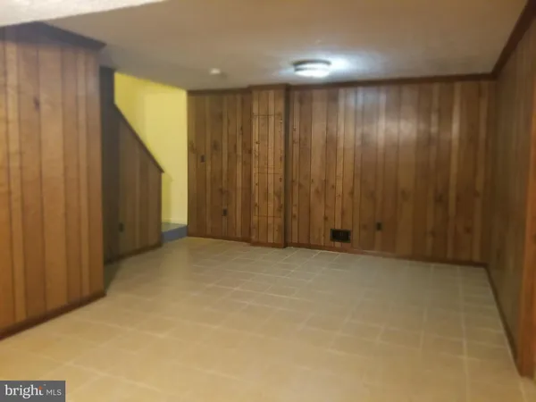 a room with water heater and wooden cabinets