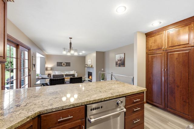 2073 Village Point Way Sandy, UT 84093 - Photo 11 of 68 Kitchen island with a light-toned granite countertop and an integrated stainless steel dishwasher.