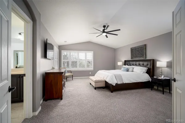 a bed sitting in a spacious bedroom next to a window