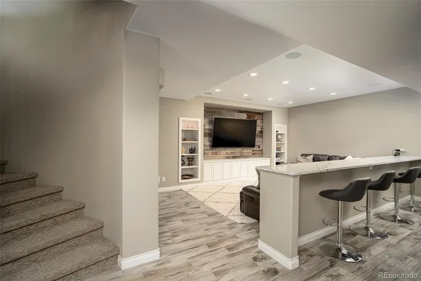 a view of a livingroom with a flat screen tv wooden floor and a fireplace