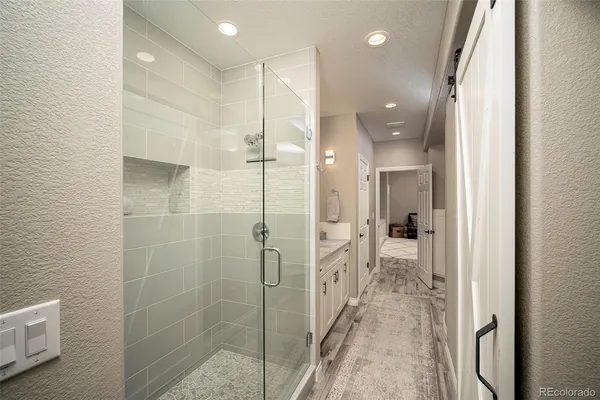 a bathroom with a glass shower door and a sink