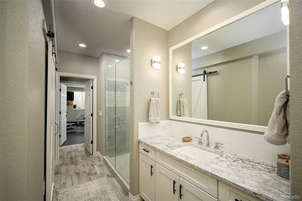 a bathroom with a granite countertop sink mirror and shower