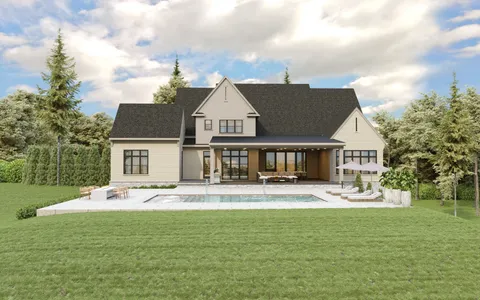 a front view of house with yard and trees in the background