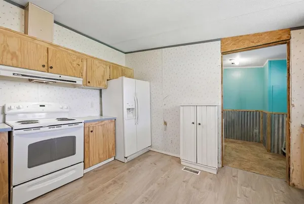 a view of a kitchen with refrigerator stove and wooden floor