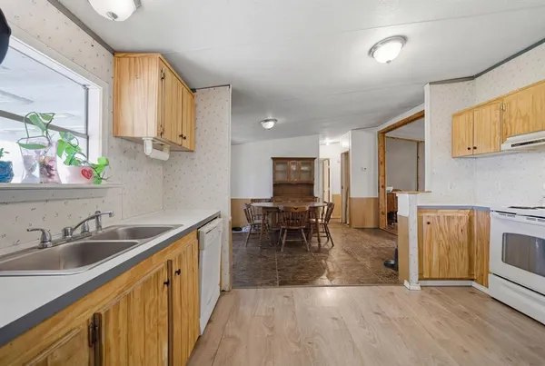 a kitchen with sink cabinets and dining table chairs