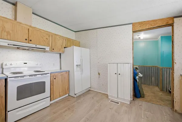 a view of a kitchen with refrigerator stove and wooden floor