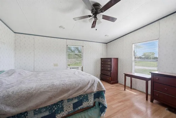 a bedroom with a bed dresser and a window