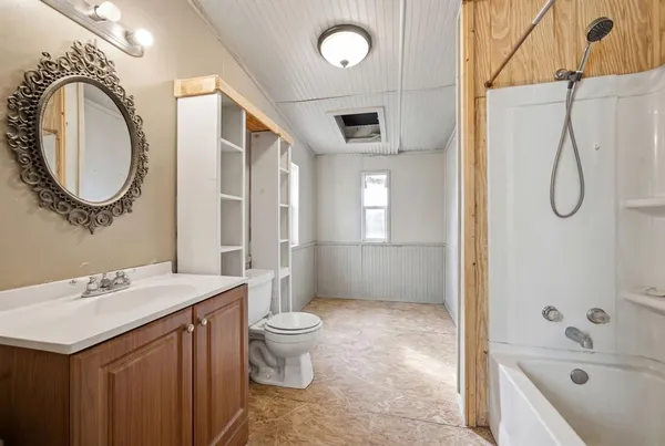 a bathroom with a sink a toilet and shower