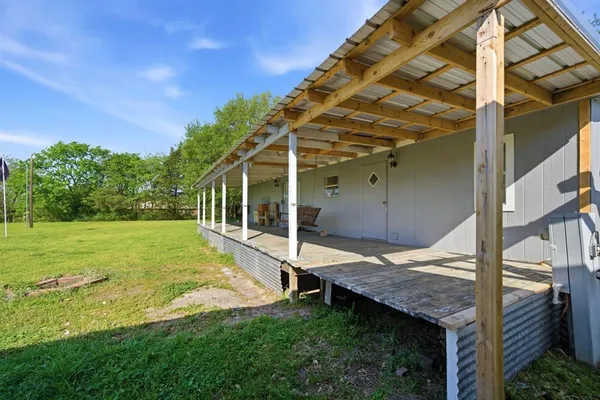 a view of a house with backyard and wooden fence