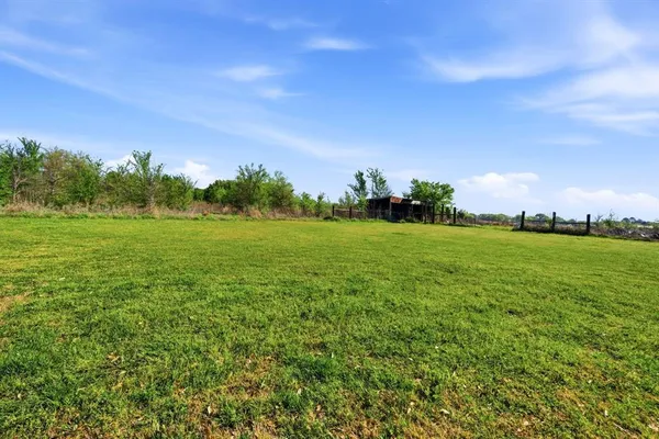 a view of a field with trees in the background