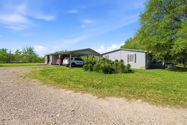 a view of house with backyard and outdoor seating