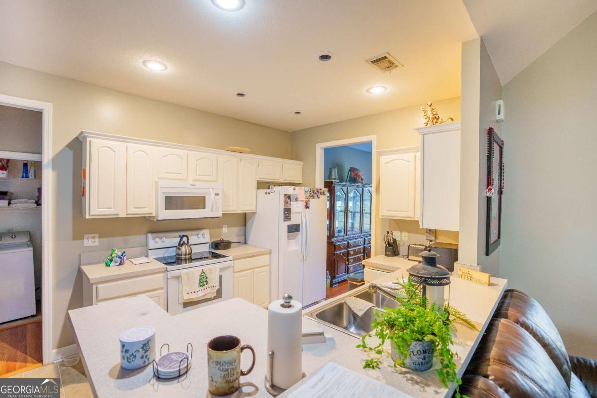 83 Gabriel Lane Baxley, GA 31513 - Photo 13 of 25 a kitchen with stainless steel appliances kitchen island granite countertop a refrigerator and a stove top oven