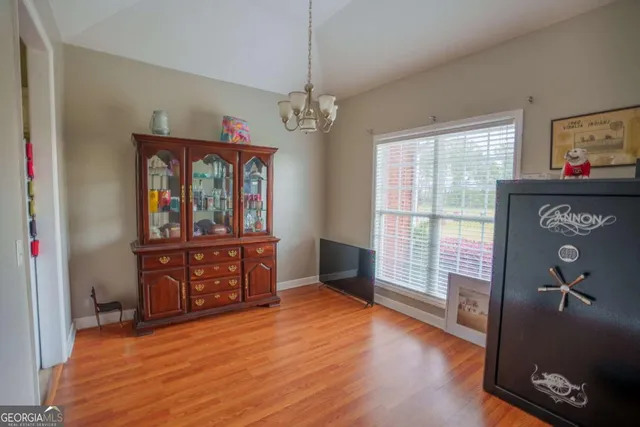 a view of a livingroom with wooden floor and furniture