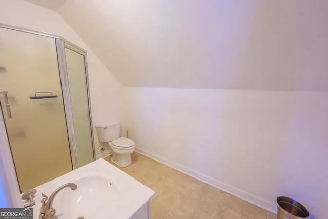 a bathroom with a toilet a sink and shower