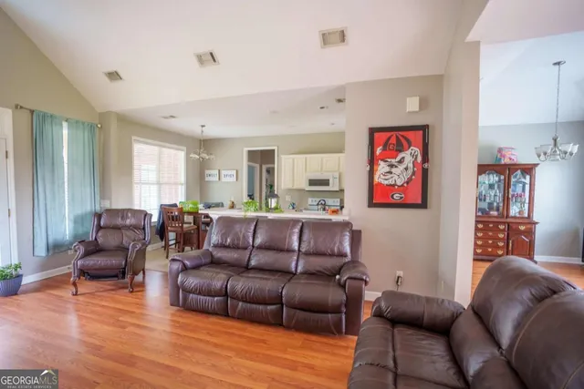 a living room with furniture kitchen view and a window