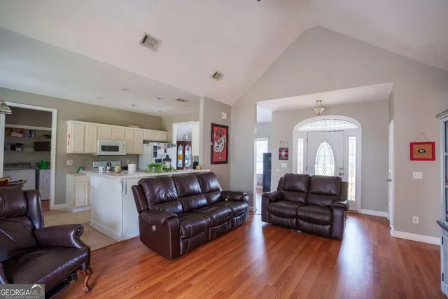 a living room with furniture and a hard wood floor