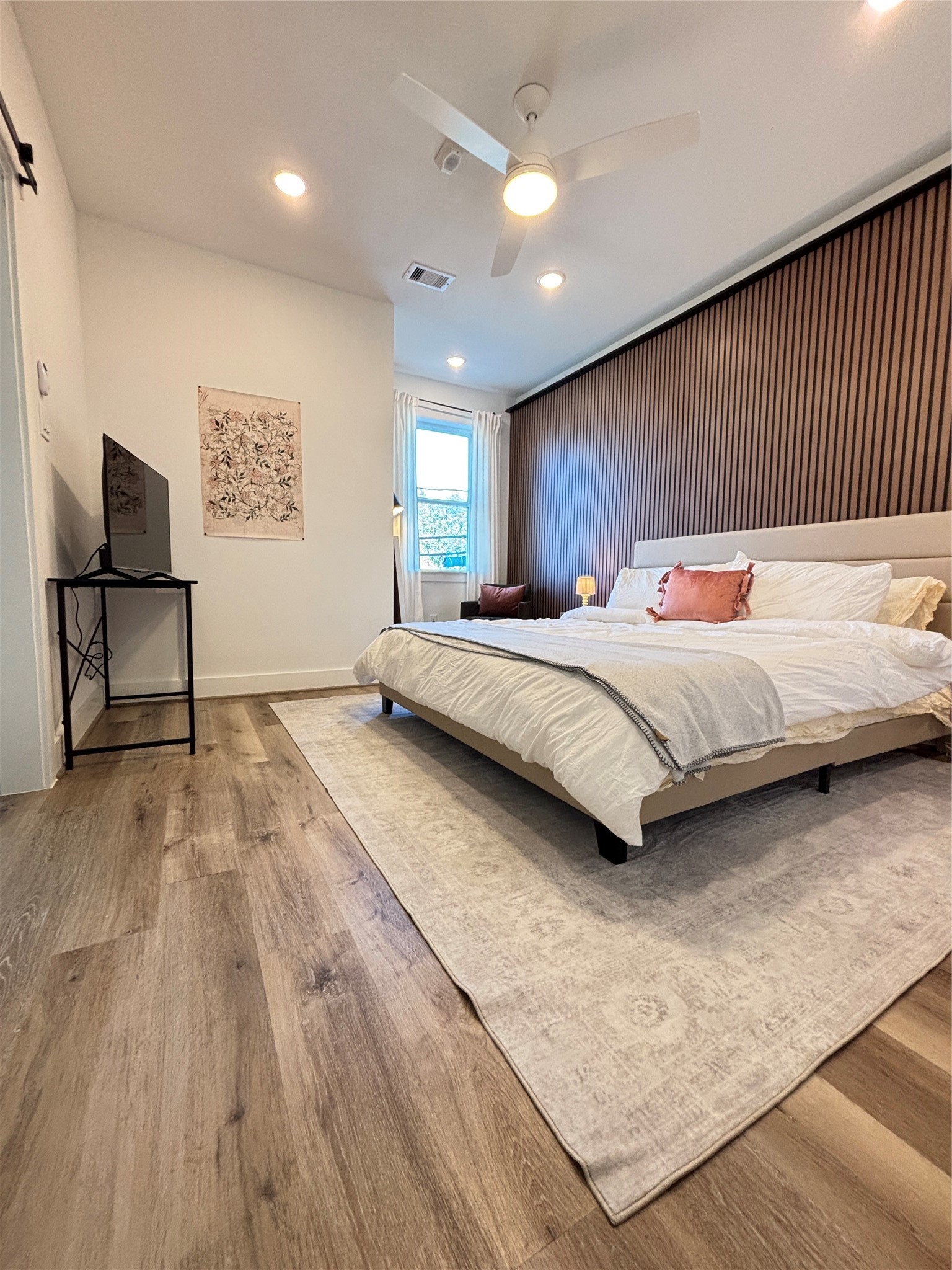 3824 Fulton Street, Unit 112 Houston, TX 77009 - Photo 4 of 15 a bedroom with a bed and a dresser with wooden floor