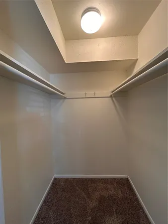 a bedroom with bed a desk and a chandelier