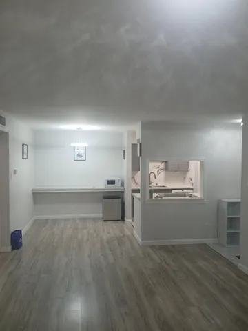 a view of a kitchen with a sink and dishwasher a stove top oven with wooden floor