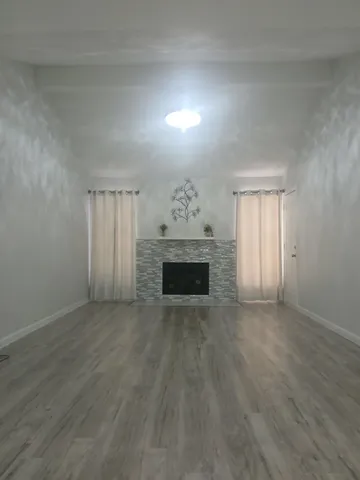 an empty room with windows and fireplace