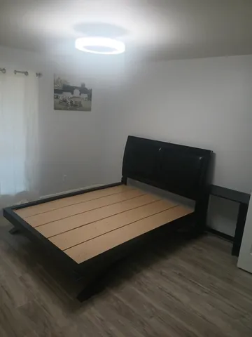 a bed sitting in a bedroom next to a lamp