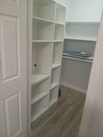 a view of walk in closet with empty racks