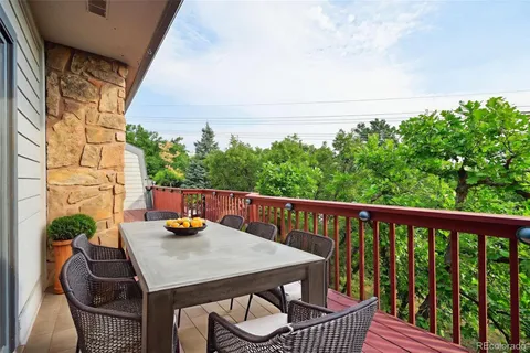 a balcony with wooden floor and outdoor seating