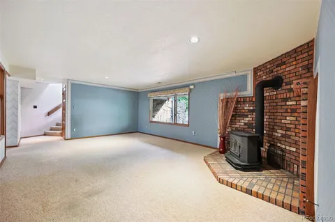 a view of an empty room with fireplace and a window