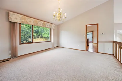 a view of a big room with windows and chandelier