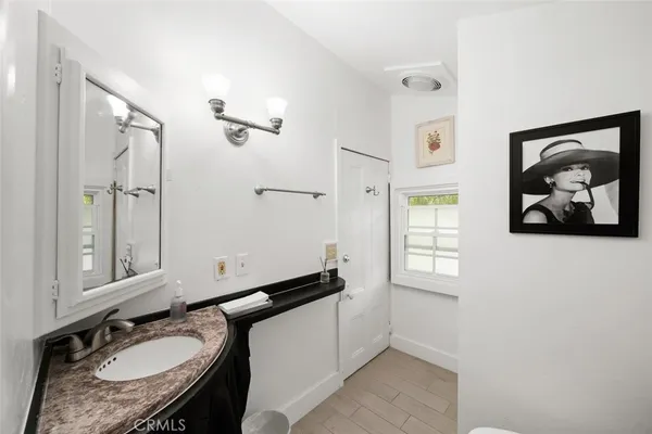 a bathroom with a white toilet sitting next to a white sink and a shower curtain