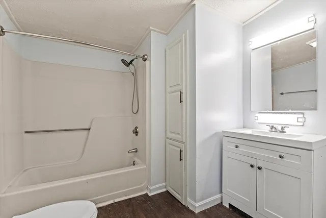 a bathroom with a tub shower vanity and a sink