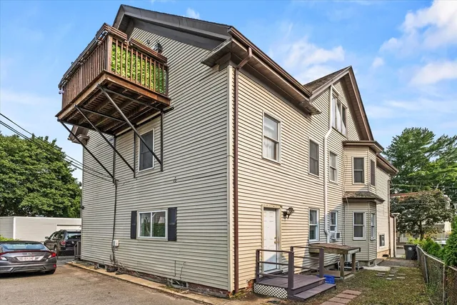 a street view with couple of cars parked in front of house