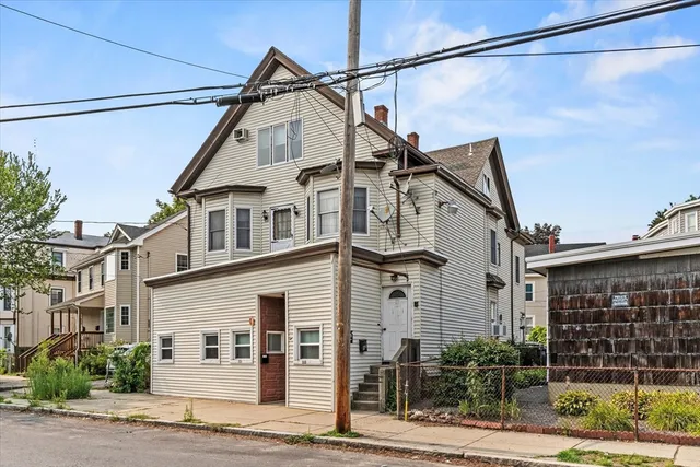 a front view of a house with a yard and potted plants