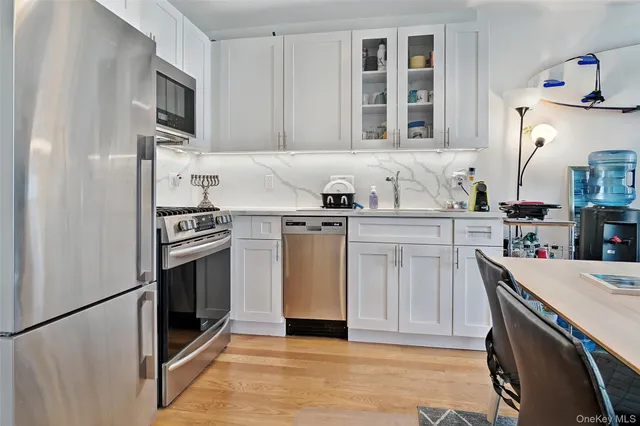 a kitchen with stainless steel appliances a stove a sink and a refrigerator