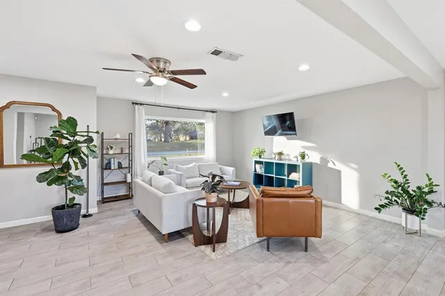 a living room with furniture a potted plant and a flat screen tv
