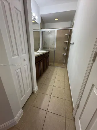 a spacious bathroom with a granite countertop sink a mirror and a shower