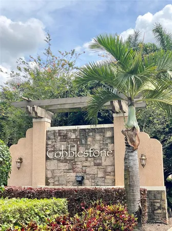 a front view of a house with a garden and trees