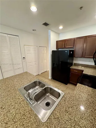 a kitchen with stainless steel appliances kitchen island granite countertop a large counter top and a stove top oven