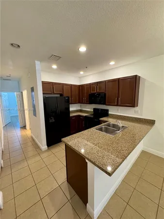 a kitchen with stainless steel appliances granite countertop a sink counter space cabinets and a stove
