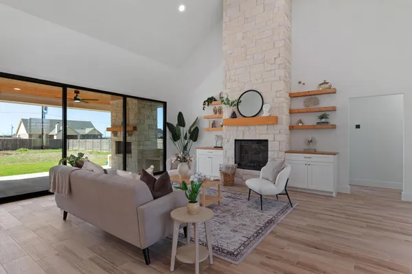 a living room with furniture a fireplace and a floor to ceiling window